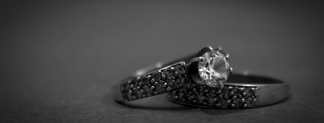 A detailed black and white close-up of elegant engagement rings with diamonds, showcasing luxury and sophistication.