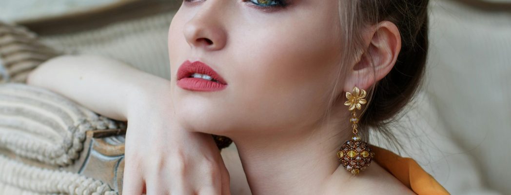 Stunning close-up portrait of a woman with elegant makeup and jewelry, epitomizing modern fashion and beauty.